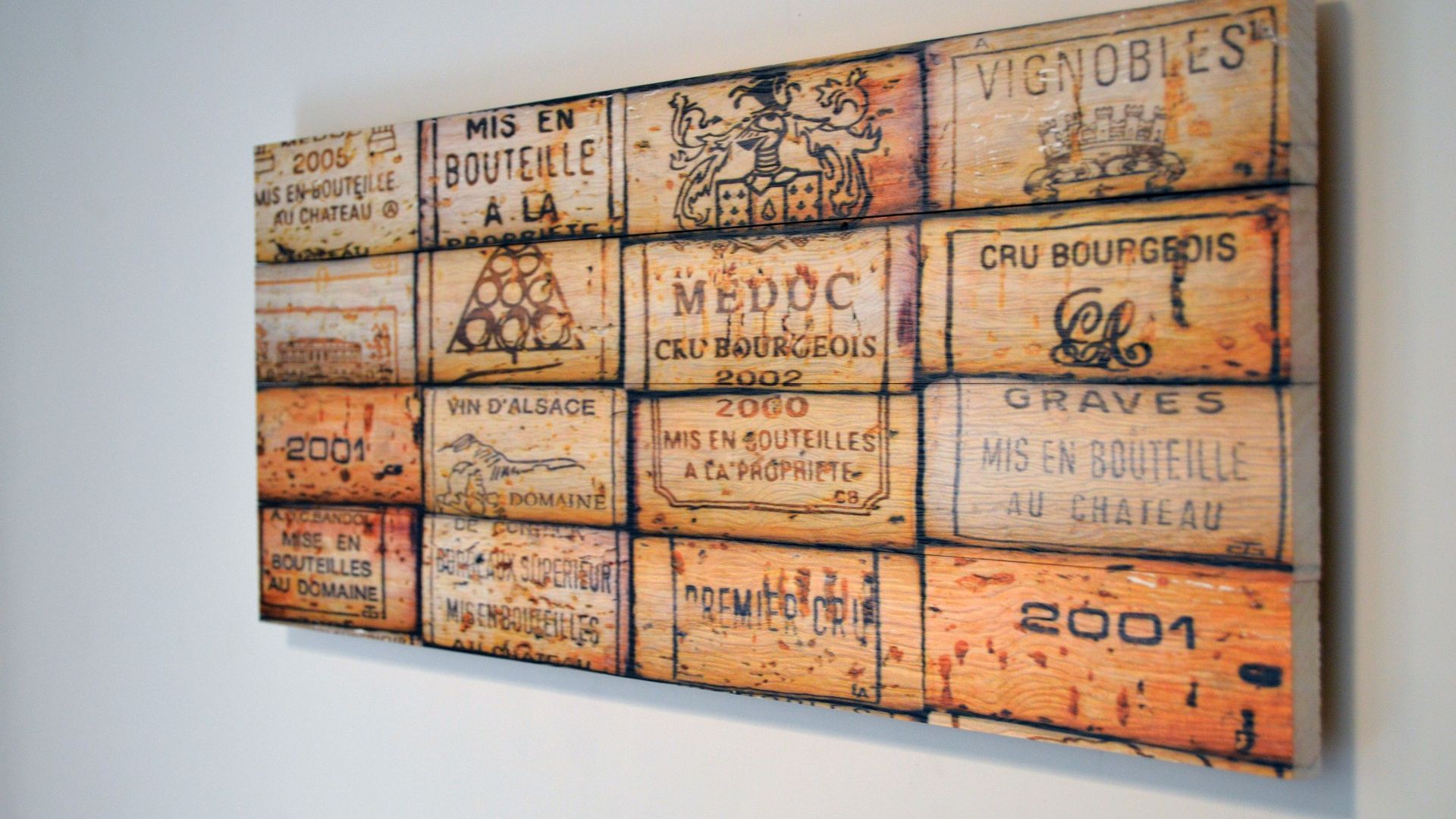 Eine Wand mit einer Reihe rechteckiger Tafeln, jeweils mit Text und einigen mit Logos, in einem Gittermuster angeordnet.