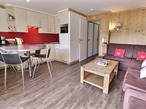 Un espacio habitable pequeño con cocina, comedor y sofá.