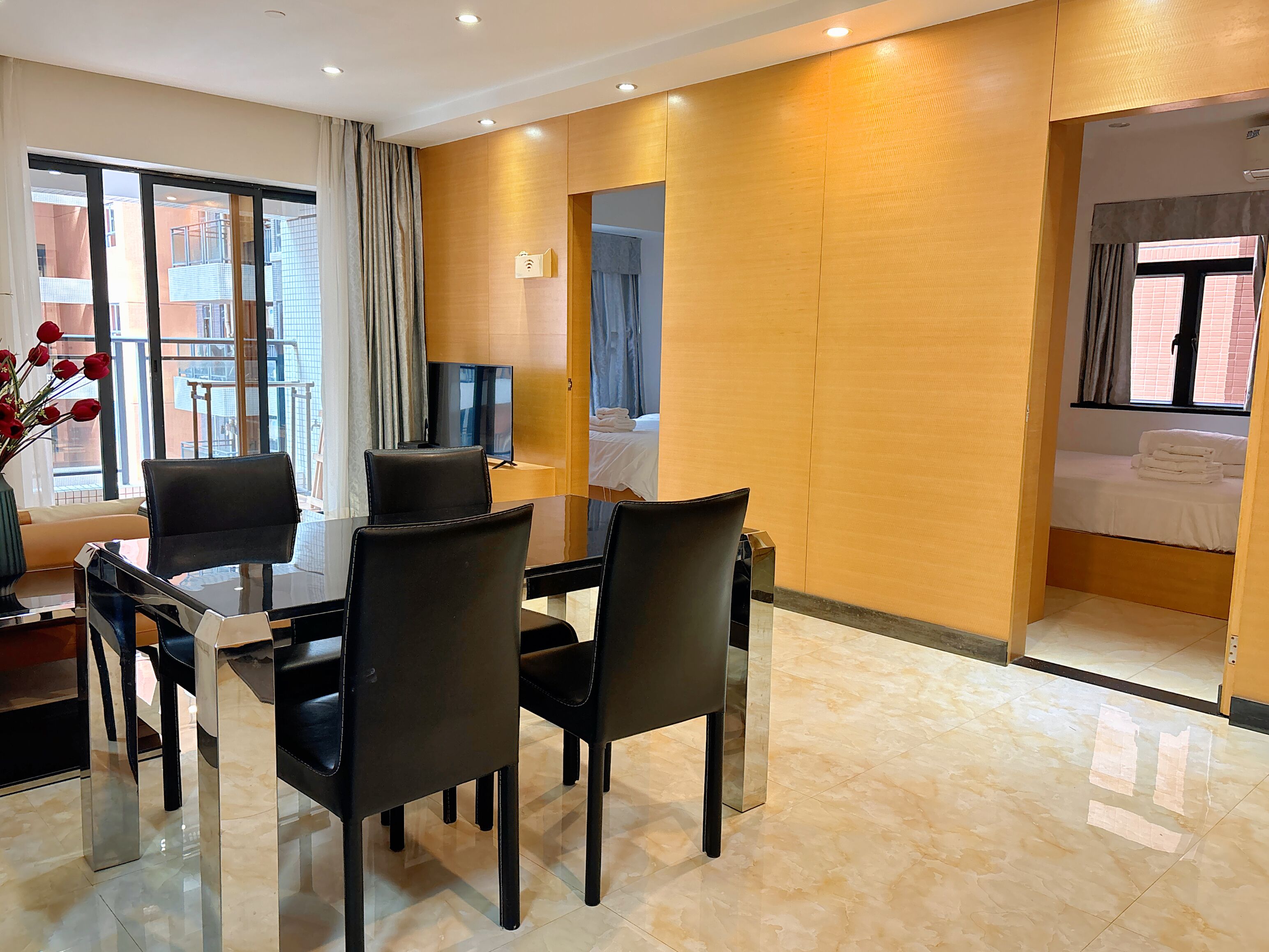 A hotel room with a dining area, a bed, and a TV.