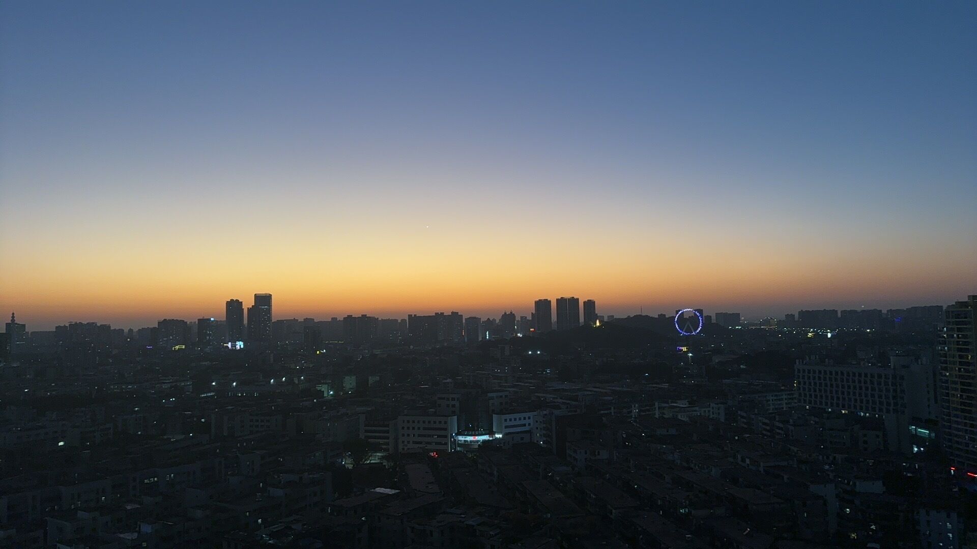 A cityscape at dusk with high-rise buildings and a clear sky.