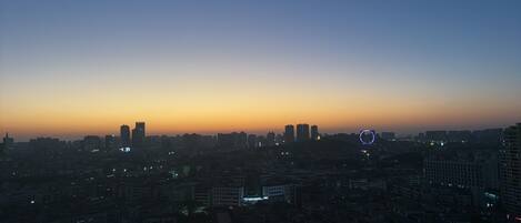 A cityscape at dusk with high-rise buildings and a clear sky.