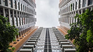 Un immeuble de grande hauteur à la façade symétrique, doté de nombreux balcons et d’un noyau central.