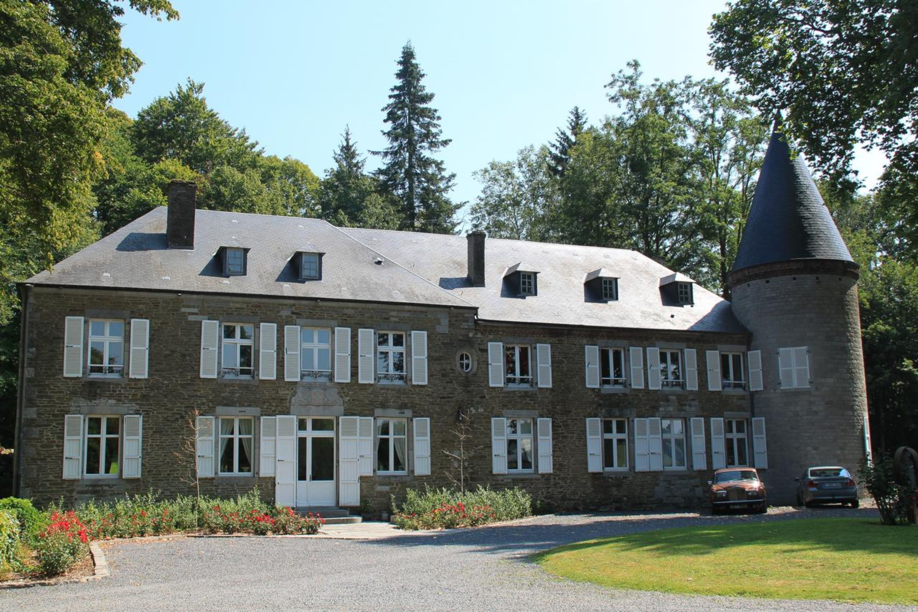 Ein Steinhaus mit zahlreichen Fenstern und einem Türmchen.