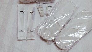 A neatly arranged set of toiletries on a bed with a checkered pattern.