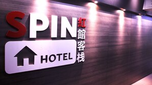A hotel sign with the name "SPIN" and a directional arrow pointing upwards.