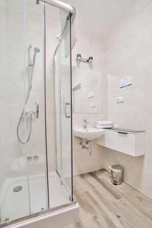Habitación estándar con 1 cama doble o 2 individuales, junto a la montaña | Baño | Ducha, artículos de higiene personal gratuitos y secador de pelo
