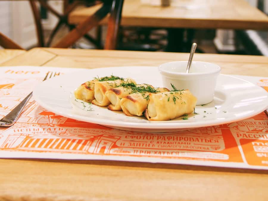 Una mesa de comedor con un plato de comida y una taza de sopa.