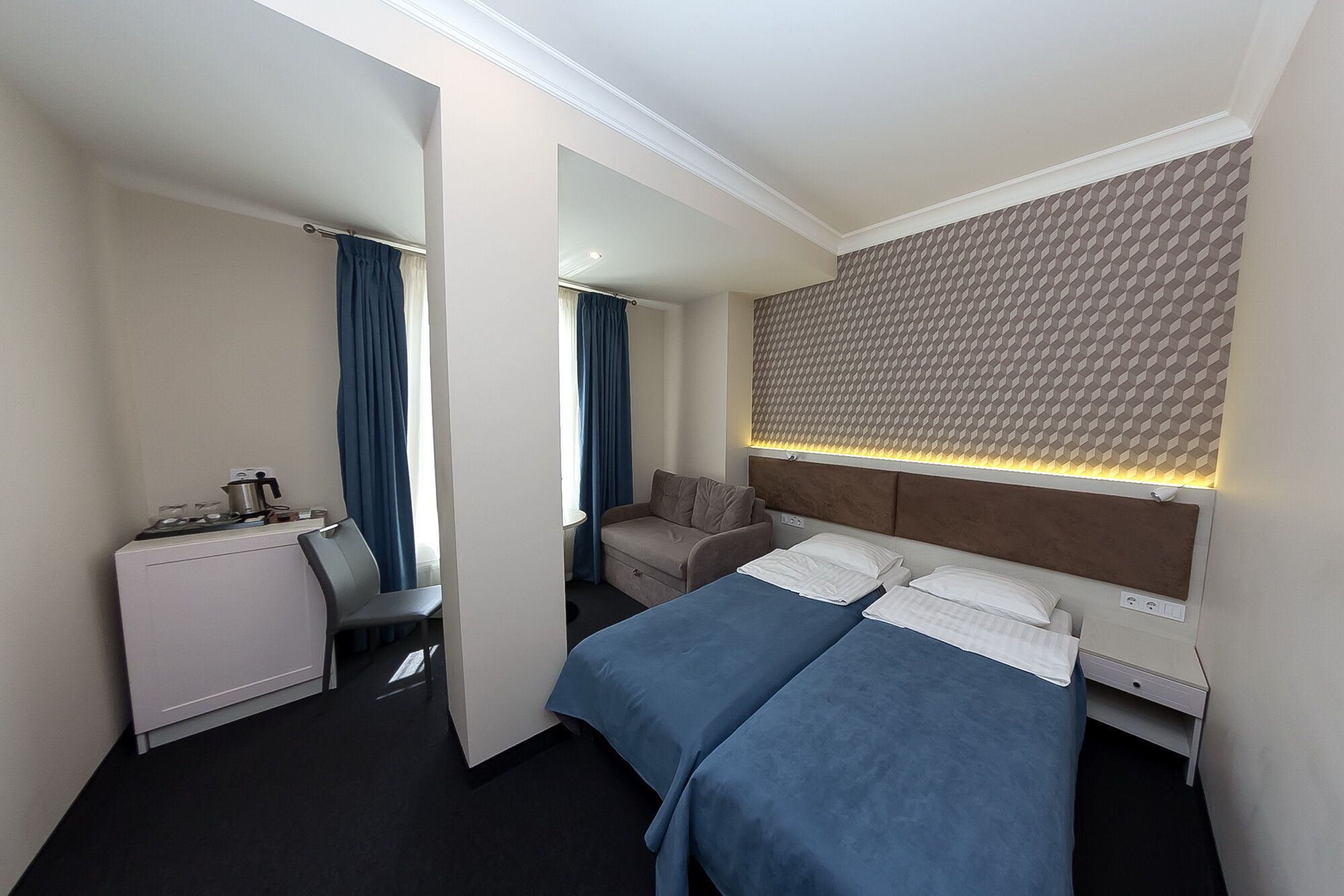 Ein Hotelzimmer mit Bett, Schreibtisch und Stuhl.