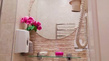 A bathroom with a sink, mirror, and towel rack.