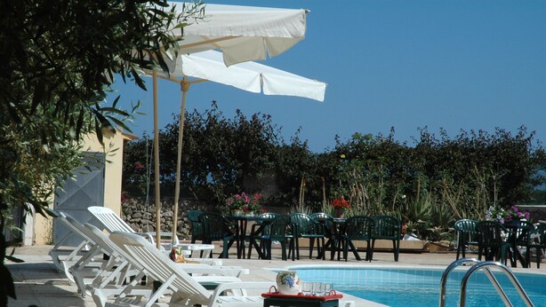 A poolside area with lounge chairs, tables, and umbrellas. - San Domenico Residence (Syracuse)