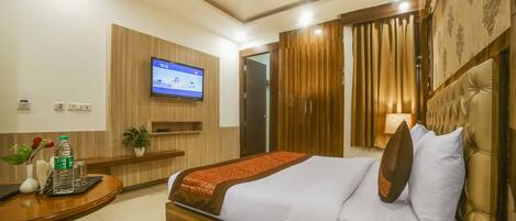A hotel room with a bed, bedside table, TV, and a telephone.
