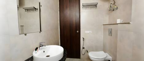 A modern bathroom with a white sink, a toilet, a shower, and a towel rack.