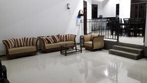 Amplia sala de estar con un conjunto de sofás, una mesa de centro y una mesa de comedor con sillas.
