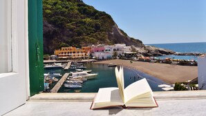 A view of a coastal town with colorful buildings, a marina, and a beach.