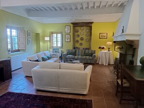 A living room with a sofa, armchairs, a fireplace, and a radiator.