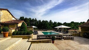 Relax by the serene pool surrounded by lush greenery and comfortable lounge chairs.