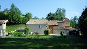 A two-story house with a tiled roof, a small garden, and a stone wall. - Le Moulin charming cottage near St Emilion (Lugaignac)