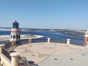 Um calçadão costeiro com um farol, uma ponte e um passeio padronizado.