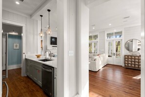 A modern kitchen with a built-in dishwasher, a sink, and pendant lighting.