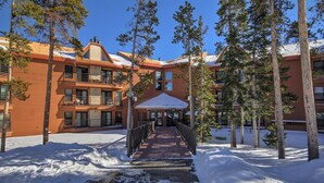 A multi-story hotel with a covered walkway leading to the entrance. - Beautiful Condo, Sleeps 8, Gorgeous Views, Wood Fireplace, HDTV, Hot Tubs - BB (Silverthorne)