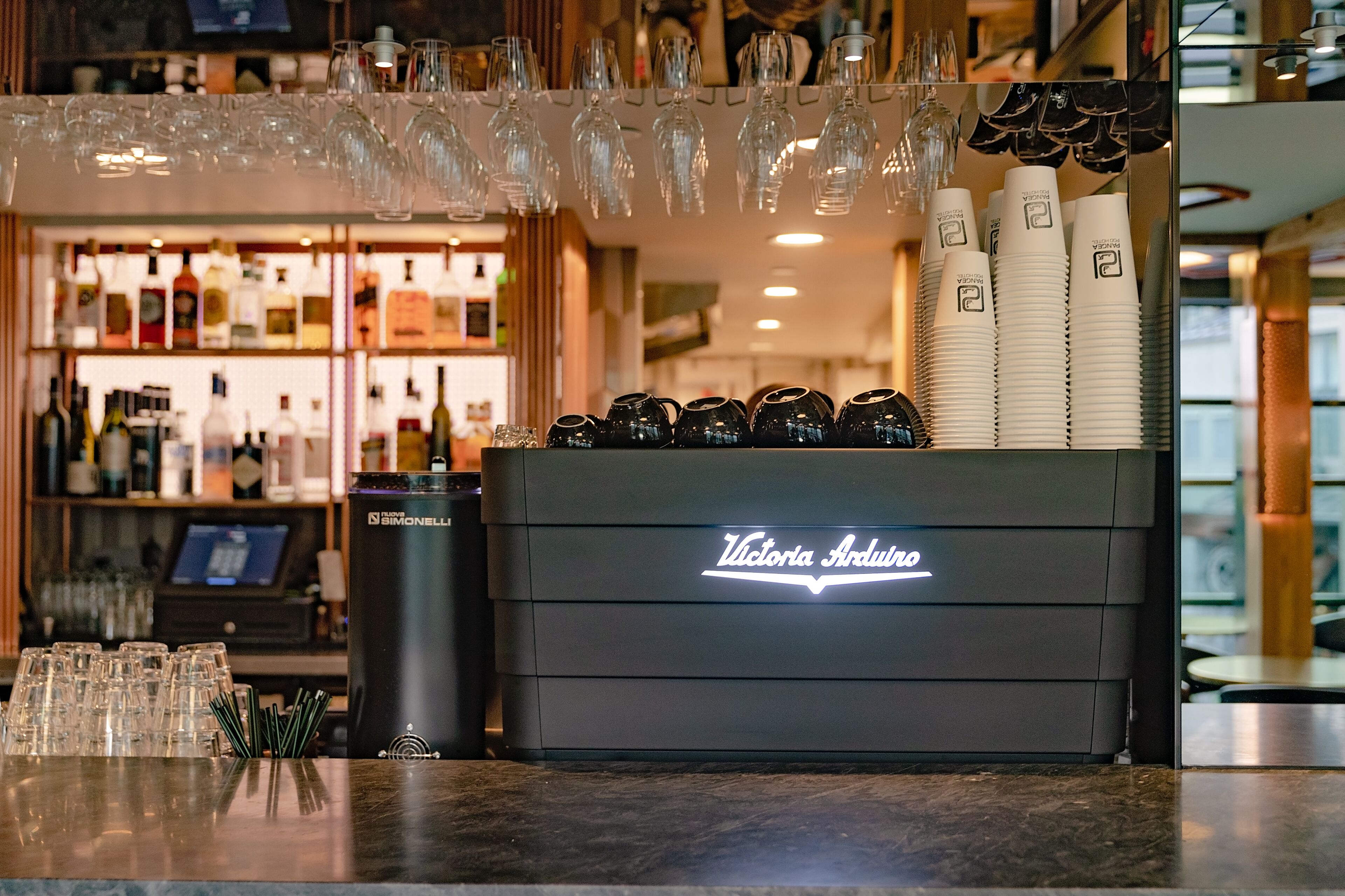 Zona de bar amb barra, gots i ampolles.