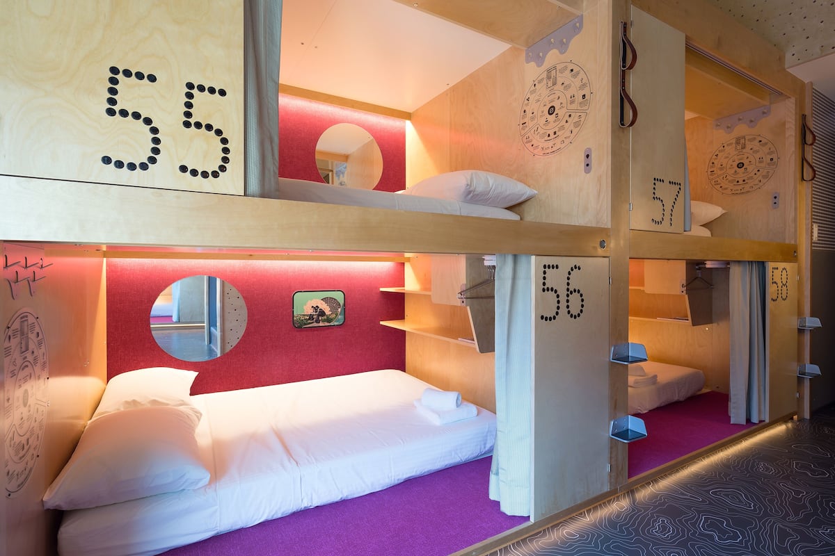 A bunk bed room with numbers on the walls, a purple carpet, and a mirror.