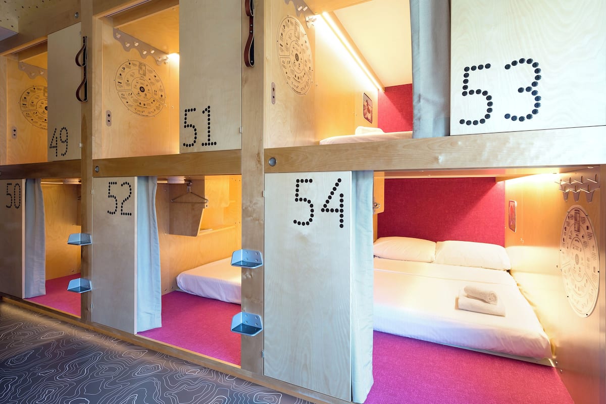 A row of bunk beds with numbers on the walls, indicating room assignments.