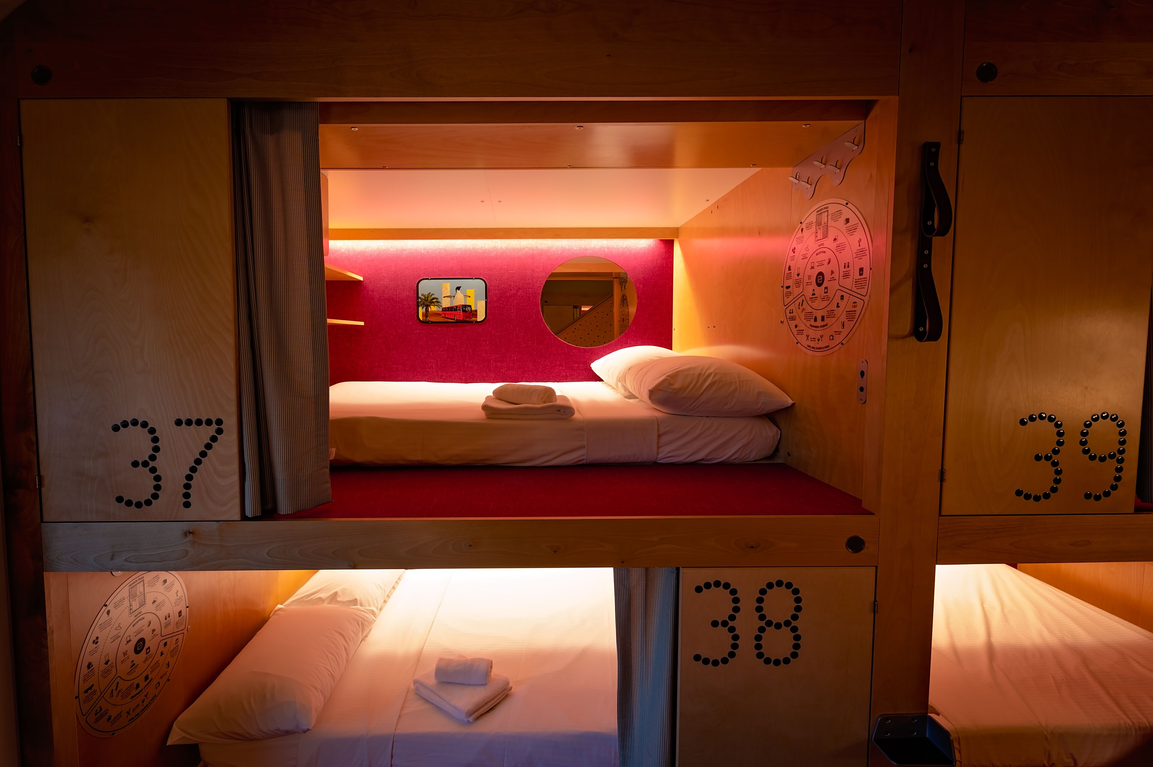 Une chambre de style cabine avec des lits superposés, chaque lit étant identifié par un numéro.
