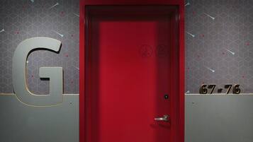 Una puerta roja con teclado numérico y cerradura de seguridad.