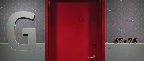 A red door with a numeric keypad and a security lock.