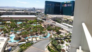 A resort with multiple swimming pools, palm trees, and a view of the MGM Grand hotel.