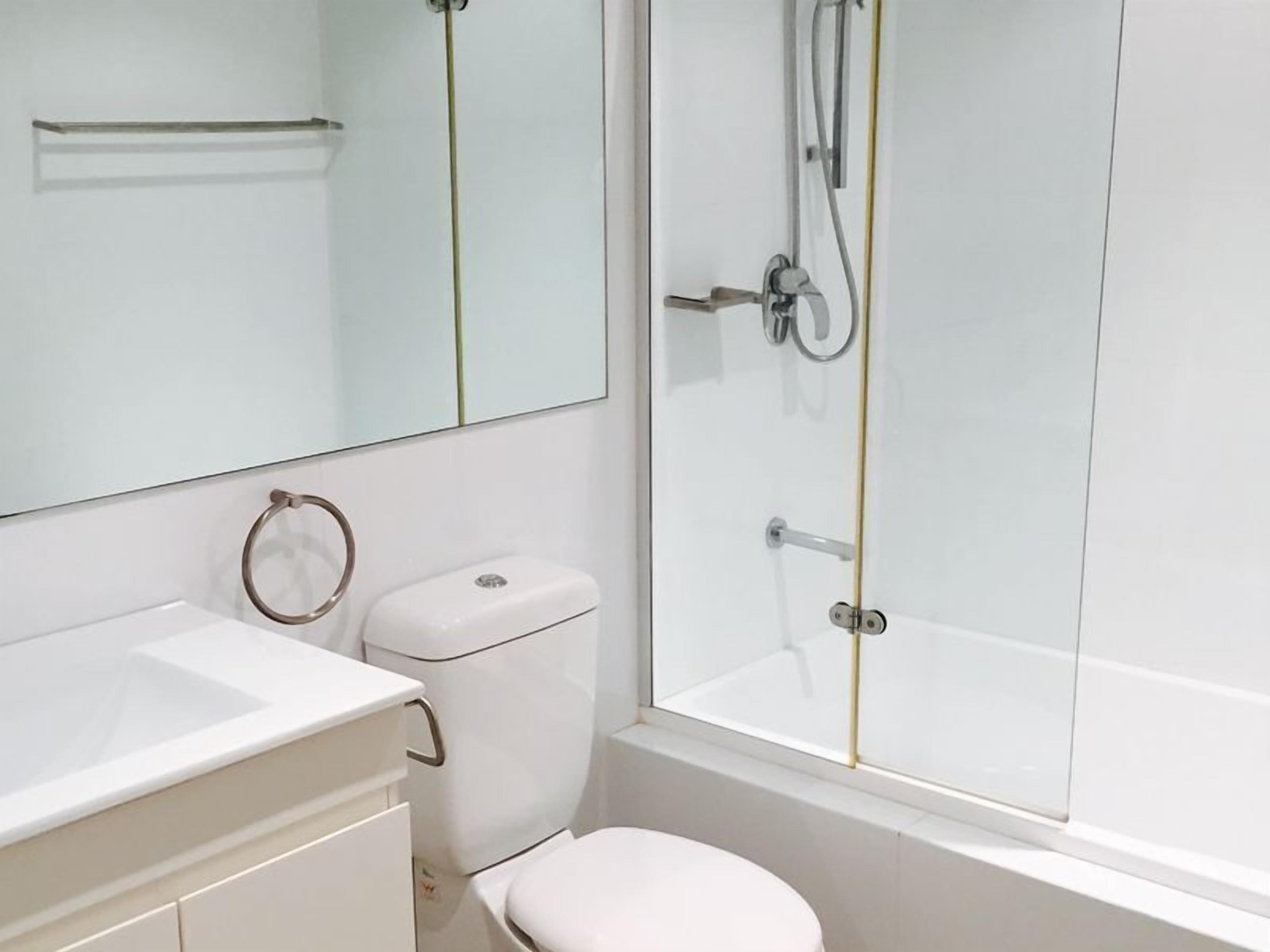 Un baño moderno con inodoro, lavabo y ducha.