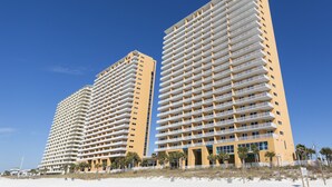 Zwei hohe Hotels mit vielen Balkonen in Strandnähe.