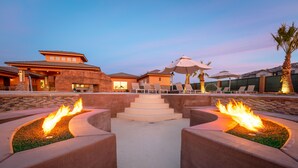 Ein Resort mit Poolbereich, inklusive Feuerstellen und Liegestühlen.