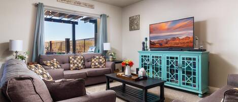 A living room with a sofa, coffee table, and a TV on a stand.