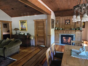 A cozy living room with a fireplace, wooden furniture, and a globe on a side table.