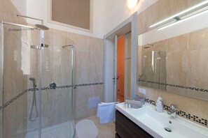 Een bad/douchecombinatie, een haardroger, een bidet, handdoeken
