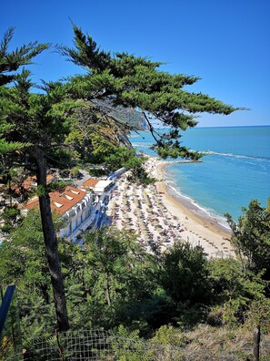 A beach with umbrellas and people, a clear sky, and a coastline. - Peaceful Rural Villa, Large Private Pool, Diving Board, Mountain & Village Views (Macerata)