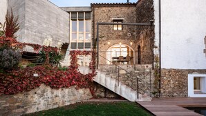 A modern building with a stone facade, a large window, and a staircase leading to an upper level. - Holiday rental townhouse with swimming pool in Begur, Centre (Begur)