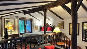 Une chambre à coucher avec un lit, un bureau, une chaise et un escalier.
