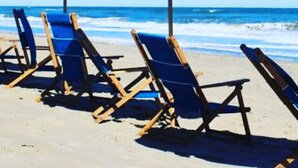 A beach with blue umbrellas and lounge chairs. - Two Crabby: Feels like home! Spectacular views, Beach Club Summer 2026! (Nags Head)