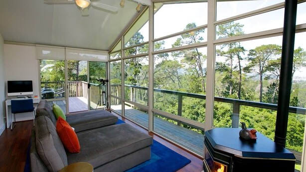 A modern living room with a sofa, a television, and a fireplace. - Jack's Peak Retreat (Carmel)