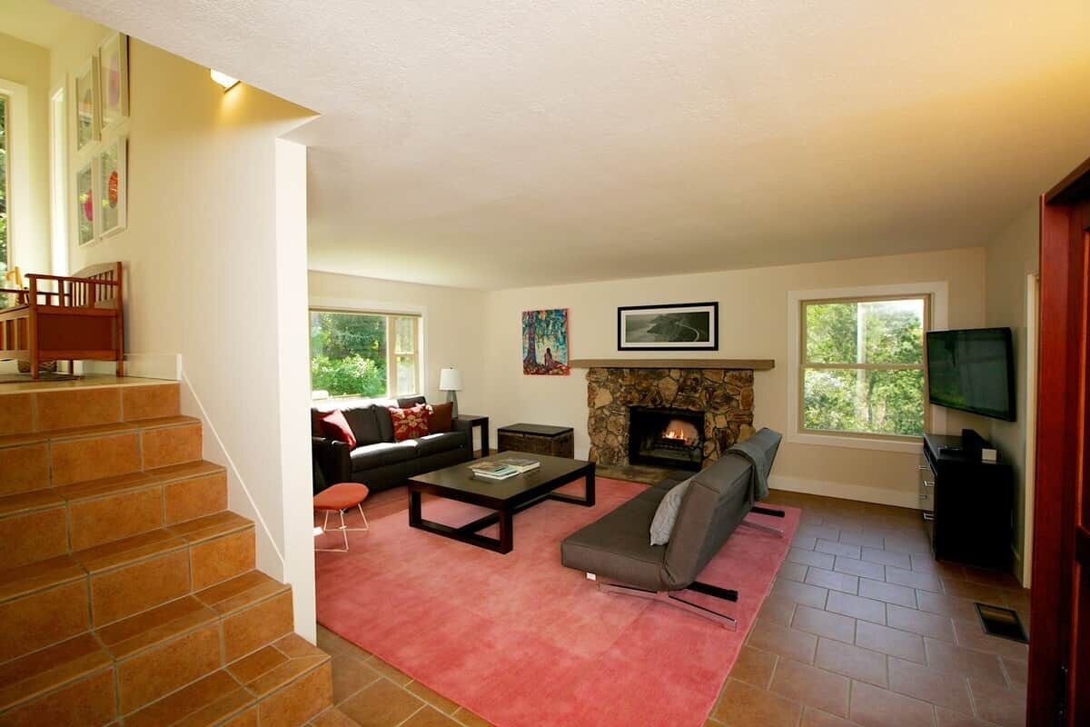 Una sala de estar con chimenea, un sofá, una mesa de centro y un televisor.