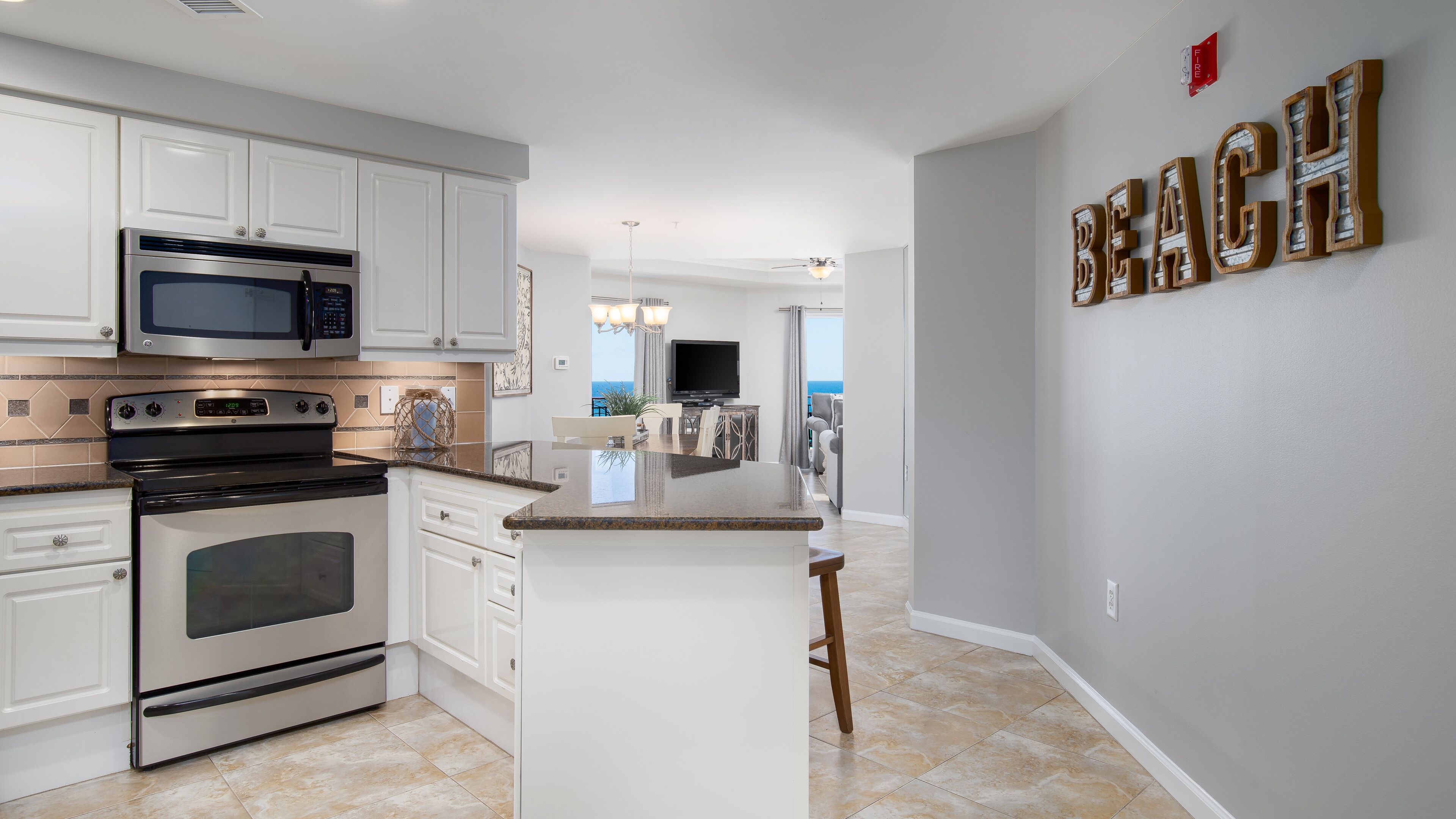 A modern kitchen with white cabinetry, stainless steel appliances, and a large island.