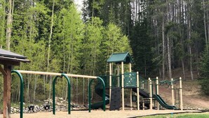 A playground with a slide, climbing structures, and a covered area. -  Family/ Pet Friendly Downtown Winter Park Condo 3BD/2BA (Winter Park)