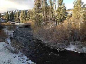 A river with a stone bridge, surrounded by trees and a mountain in the background. -  Family/ Pet Friendly Downtown Winter Park Condo 3BD/2BA (Winter Park)