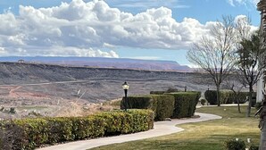 A curved driveway leading to a house with a view of a mountainous landscape. - Pure Comfort - 3 bedroom/2 bath Las Palmas Condo  (St George)