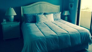 A neatly made bed with a headboard, two bedside tables with lamps, and a window with a view. - Check This One Out! Best Location-Quiet And Nice Wide Beach-Direct Ocean Front (Myrtle Beach)