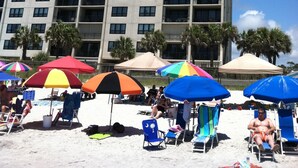 A high-rise hotel with multiple balconies and a beach area with colorful umbrellas. - Check This One Out! Best Location-Quiet And Nice Wide Beach-Direct Ocean Front (Myrtle Beach)