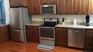 A kitchen with wooden cabinets, stainless steel appliances, a granite countertop, and a striped rug. - Waterfront Paradise- 10 minutes from downtown Chattanooga (Chattanooga)